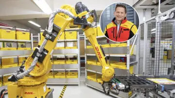 Zautomatyzowany magazyn DHL, duża giełda niemiecka, z robotem i uśmiechniętym menedżerem.