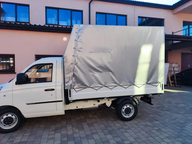 Biały samochód ciężarowy do 2,5 tony z plandeką gotowy do transportu towarów.